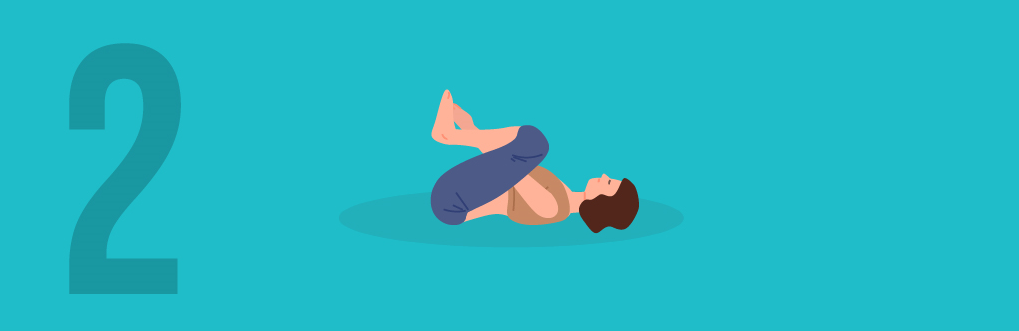  Woman lying on the ground with both knees up and arms in between her legs in a wind-relieving yoga position (Happy Baby Pose)